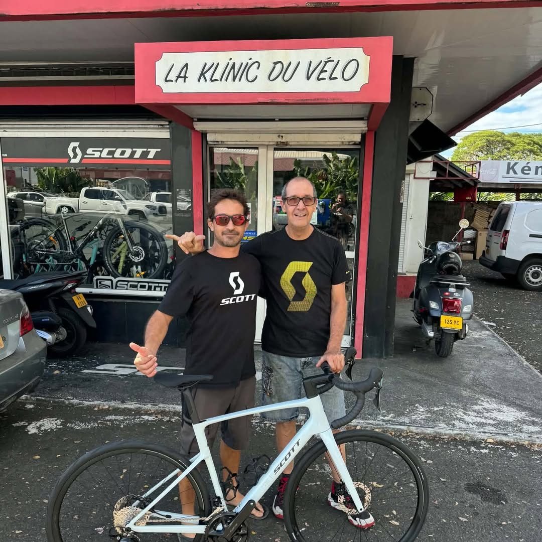 Devant la boutique La Klinic du Vélo à Pirae, deux cyclistes avec un vélo SCOTT